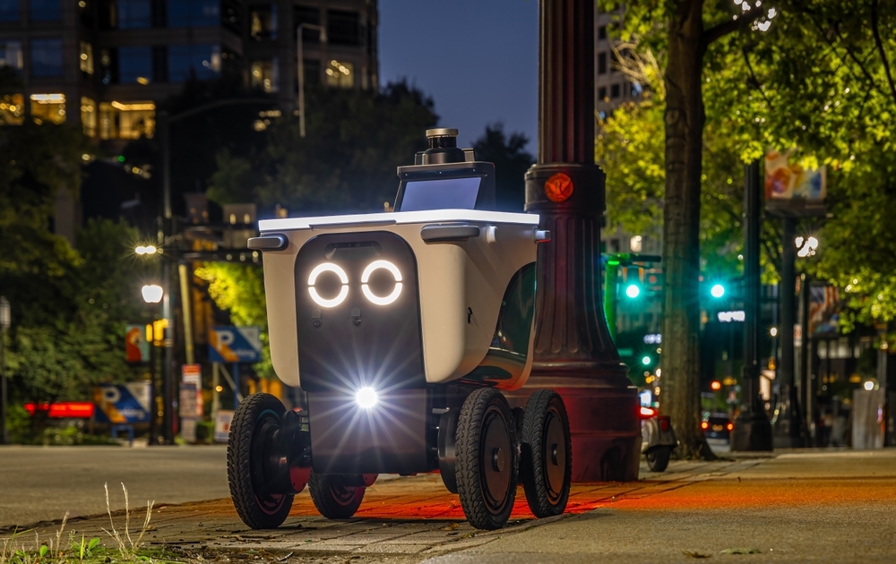 Cute, wheeled delivery robot operating on a city sidewalk in Atlanta at night